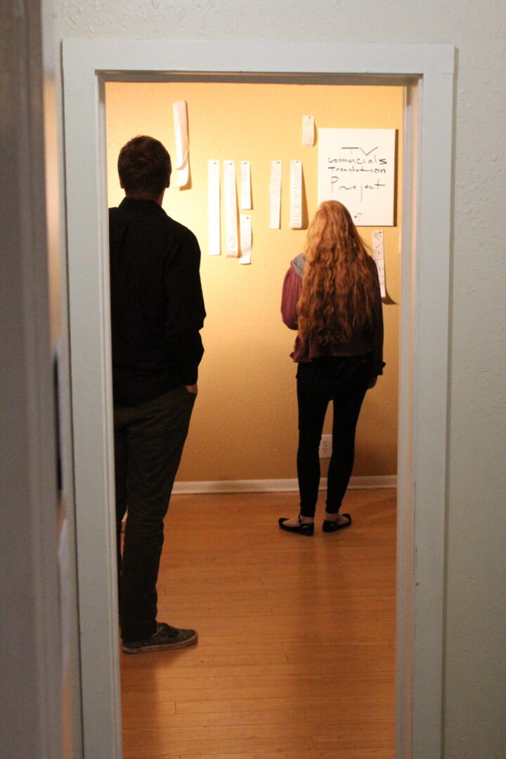 Girl standing near the wall and a boy standing behind him